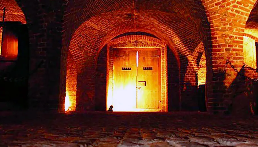 A warmly lit wooden door is set within an arched brick entryway, creating a cozy, mysterious atmosphere.