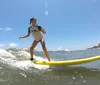 An exuberant person celebrates while successfully surfing a small wave