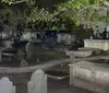 The image captures a nighttime scene of an old cemetery with tombstones and graves illuminated by faint lighting