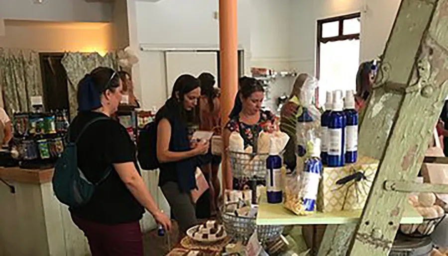 The image shows a group of people browsing products at an indoor market or boutique shop.