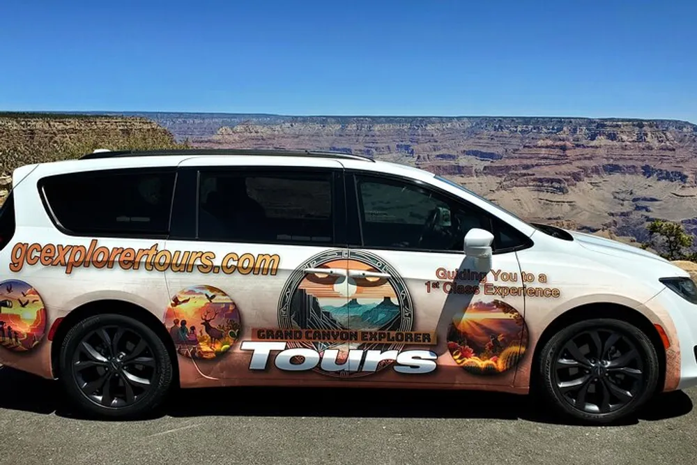 A tour vehicle with a custom wrap advertising Grand Canyon Explorer Tours is parked in front of a scenic view of the Grand Canyon