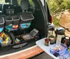 A tour van featuring advertising graphics is parked in front of the Grand Canyon