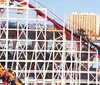 A joyful family is laughing and posing in front of the BELMONT PARK sign at an amusement park