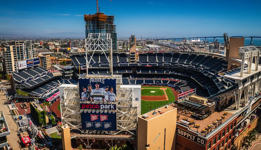 The image shows Petco Park a baseball stadium surrounded by cityscape with a large billboard featuring the San Diego Padres team