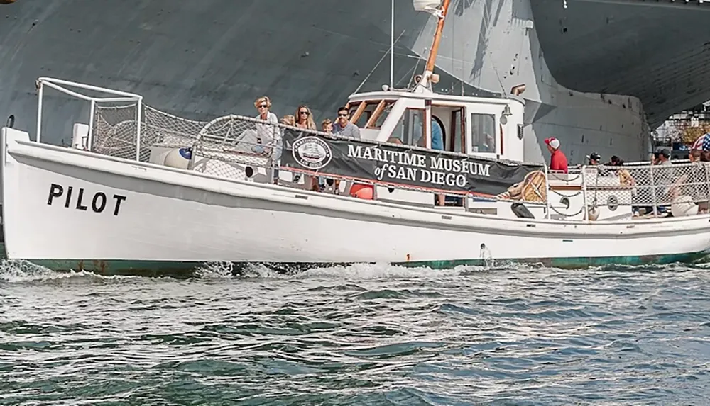 A boat labeled PILOT associated with the Maritime Museum of San Diego is carrying people on the water