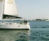 A group of people is enjoying drinks and smiling on a sailboat under sunny skies