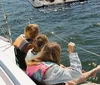 A group of people is enjoying drinks and smiling on a sailboat under sunny skies