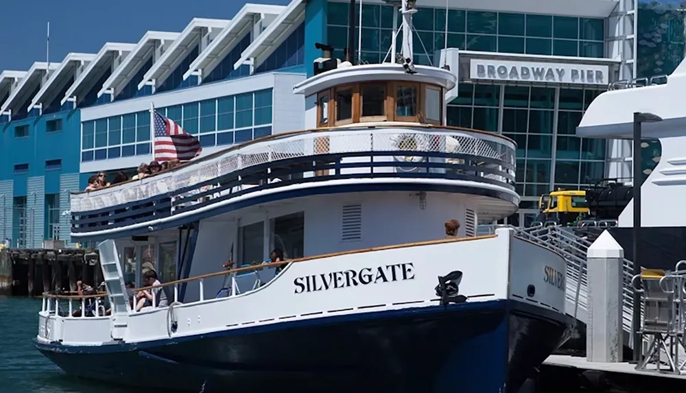 A ferry named Silvergate is docked at Broadway Pier with passengers on board and an American flag displayed