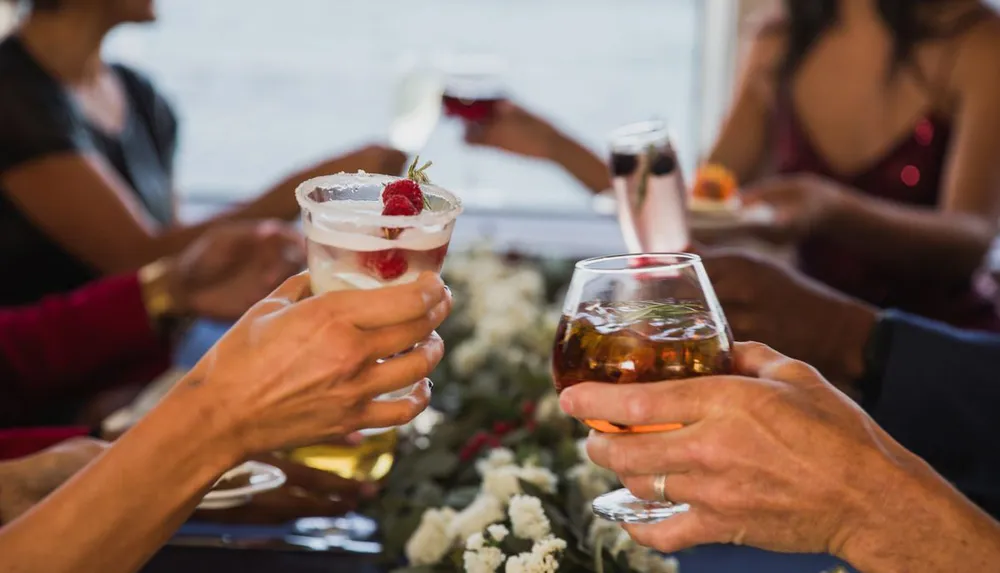 A group of people are toasting with various drinks in a festive setting