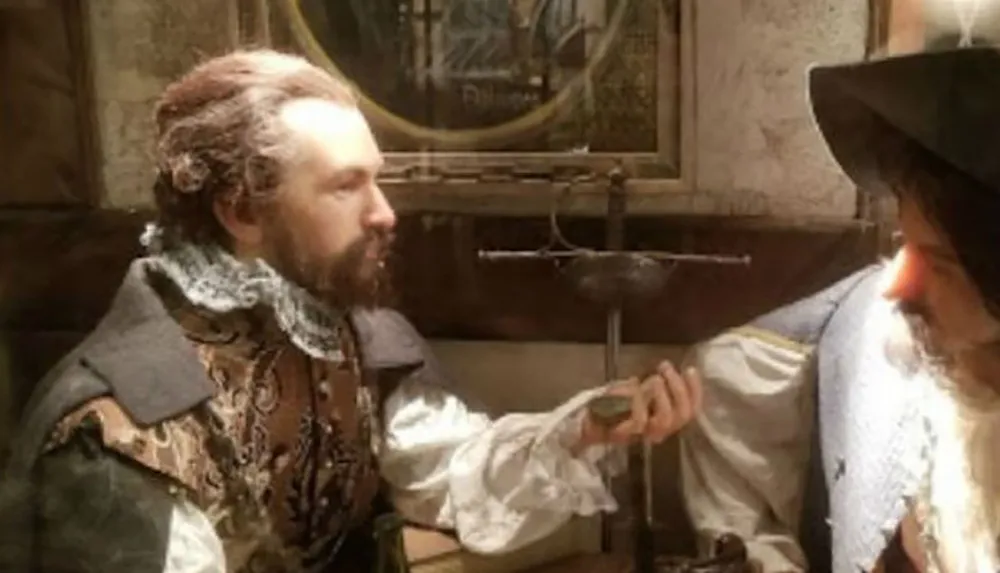 The image depicts two men in historical clothing engaged in a conversation with one holding a coin and a scale in the background