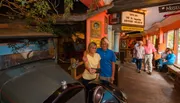 A couple is taking a selfie in front of an antique car inside Gator Bob’s Old St. Augustine History Museum.