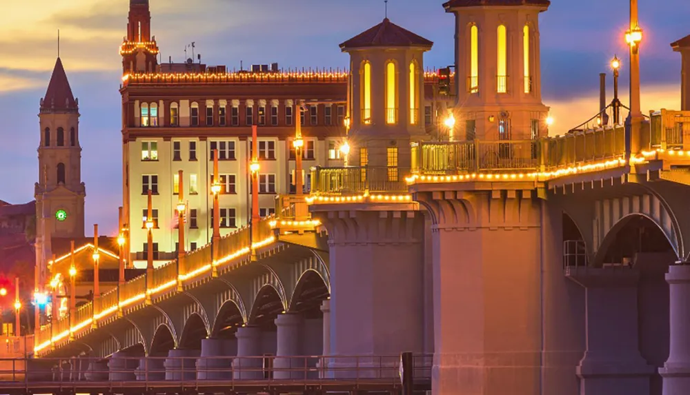 The image shows a beautifully lit bridge at sunset with historic buildings in the background