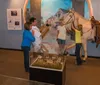 People are enjoying a museum exhibit featuring a horse and a historical diorama