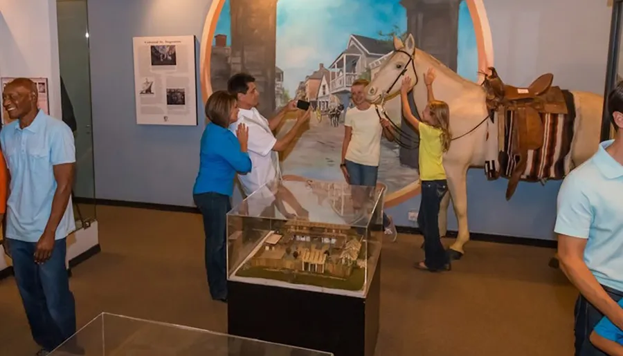 People are enjoying a museum exhibit featuring a horse and a historical diorama.