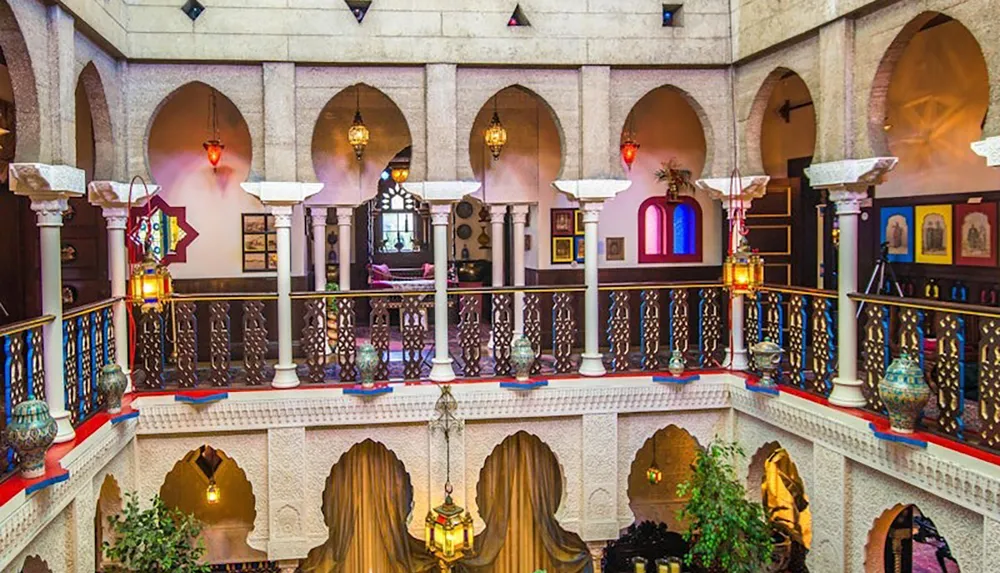 The image depicts an intricately designed multi-level interior space inspired by Middle Eastern architecture featuring arched doorways ornate columns decorative lanterns and vibrant colored accents