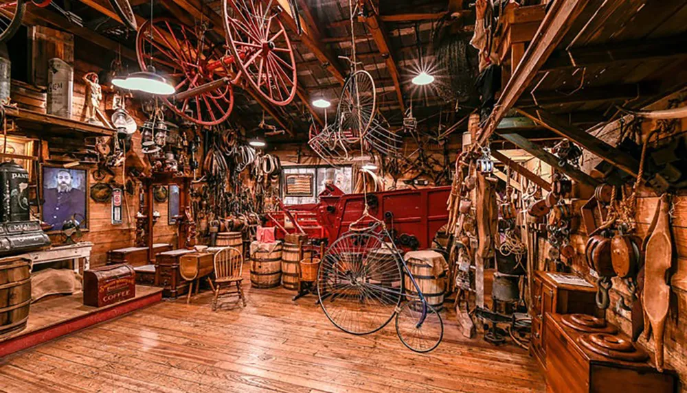 The image depicts a cluttered antique store filled with vintage items including old bicycles wooden barrels and various household artifacts