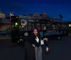 A woman in period costume holds a lantern in front of a Ghosts  Gravestones trolley at night