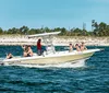 A group of people are enjoying a sunny day on a white and yellow Pro-Line motorboat near the shore with clear blue skies above them