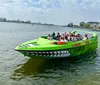 A group of people is enjoying a ride in a bright green shark-themed tour boat on a calm body of water