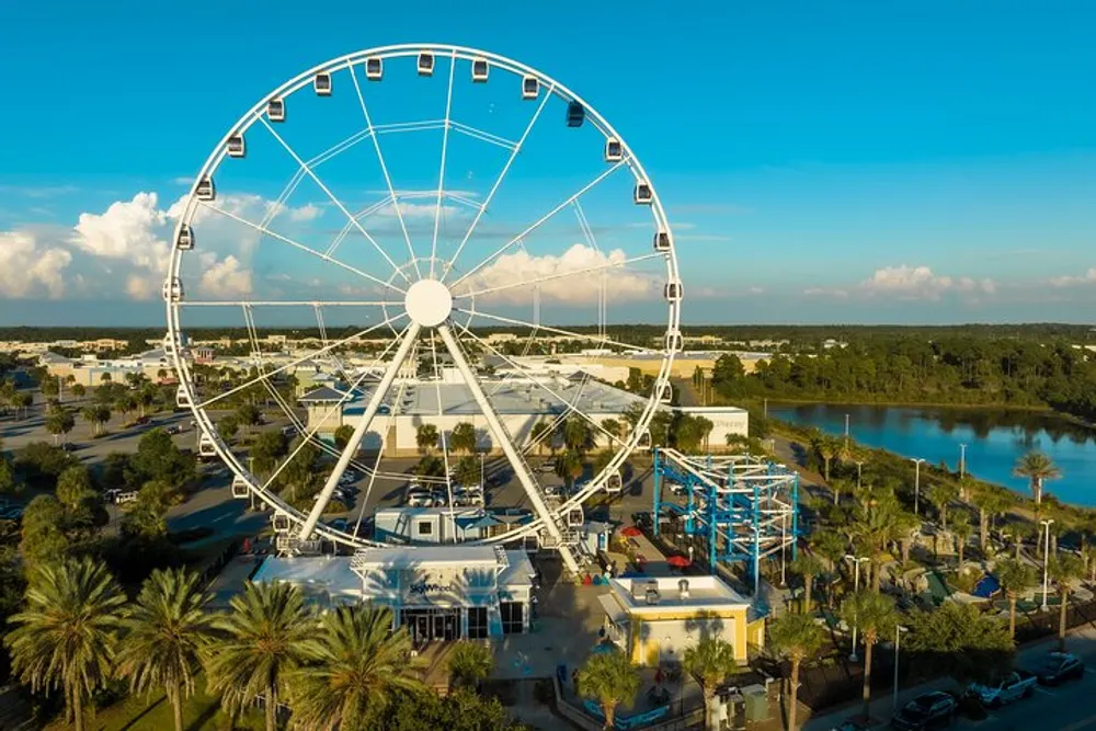 A large Ferris wheel dominates the scene in an amusement area with a clear blue sky in the background