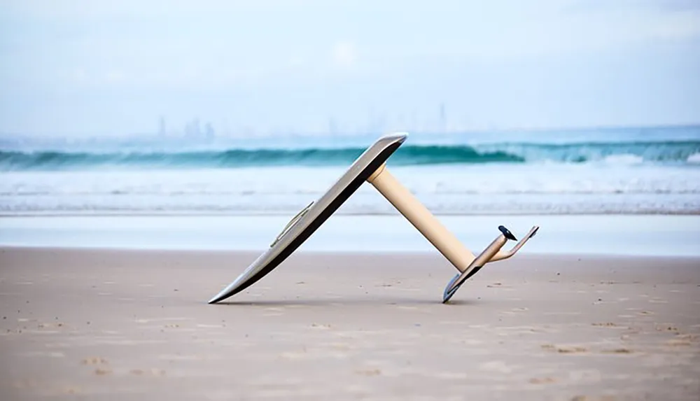 A large metallic-looking table knife half-buried in the sand gives the illusion of being stuck into the beach with the ocean and a blurred city skyline in the background