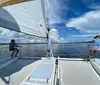 A group of people are joyfully posing on a boat during what appears to be a sunset sailing trip