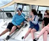 A group of people are joyfully posing on a boat during what appears to be a sunset sailing trip