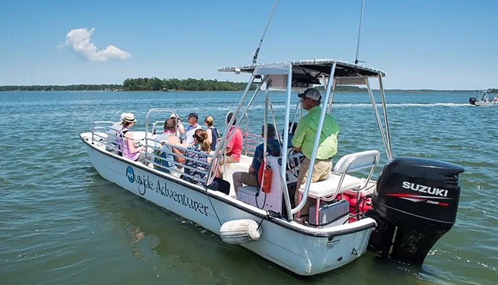 A group of people are enjoying a boat ride on a clear day in a vessel named Osprey Adventurer powered by a Suzuki outboard motor