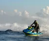 A person in a life vest is riding a jet ski on the sea creating a splash of water around them