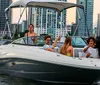 A group of people are enjoying a boat ride near a coastline lined with modern buildings during dusk