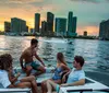 A group of friends is enjoying a boat ride against a backdrop of a vibrant sunset and the city skyline