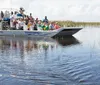 A group of tourists is enjoying a ride on an airboat through a waterway with sparse vegetation