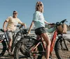 A man and a woman are smiling and posing with their bicycles on a sunny pier suggesting a leisurely day out