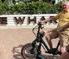 A group of people is enjoying a sunny day riding electric bikes along a palm-lined pathway