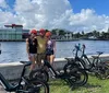 A group of people is enjoying a sunny day riding electric bikes along a palm-lined pathway