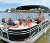 A group of people is enjoying a sunny boat ride with some individuals posing for the camera showcasing a cheerful and leisurely experience