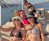 A group of people is enjoying a sunny boat ride with some individuals posing for the camera showcasing a cheerful and leisurely experience