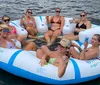 A group of women are relaxing and enjoying drinks on a large inflatable raft on the water