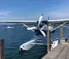 A seaplane is taking off from a calm lake creating a spray of water