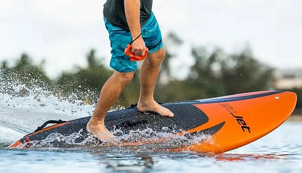 A person is stand-up paddleboarding on calm water with a splash as they paddle