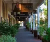 The image shows a shaded outdoor gallery lined with shops and potted plants featuring a sign for Shiprock Santa Fe