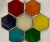 The image shows a collection of hexagonal stained glass panels in various colors assembled together to form a honeycomb-like pattern