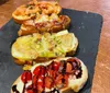 The image shows a variety of four bruschetta toppings on toasted bread artistically arranged on a slate serving board