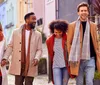 Four friends are laughing and enjoying a lively conversation on a sunny urban street