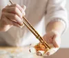 A person is pan-frying dumplings on a stovetop