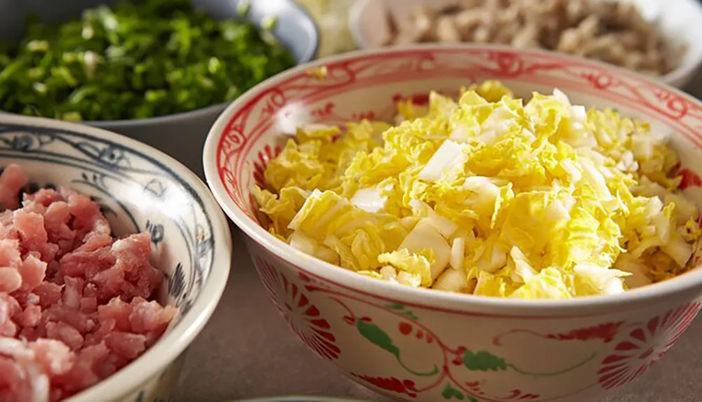 This image shows a variety of fresh ingredients including chopped leafy green vegetables diced meat and shredded cabbage which are commonly used in preparing a meal