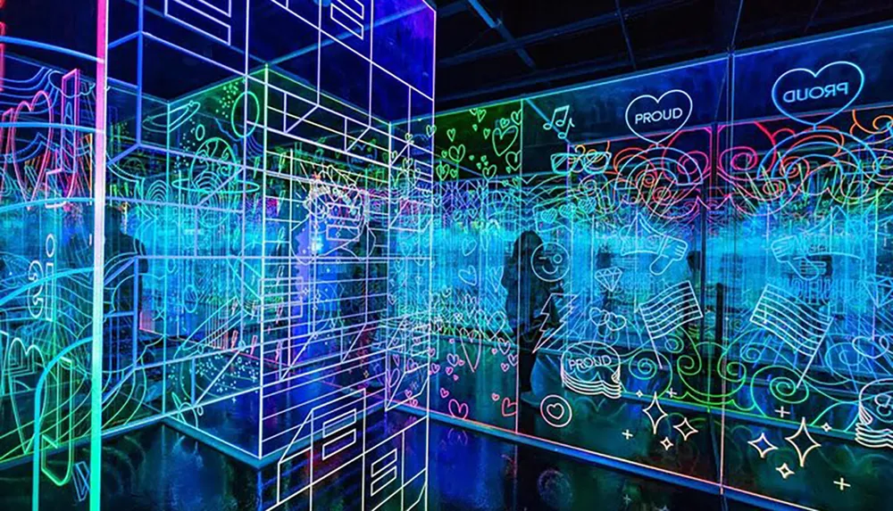 The image depicts a vibrant and colorful neon-lit space with graffiti-style drawings and symbols on transparent walls creating a visually stimulating three-dimensional light maze environment