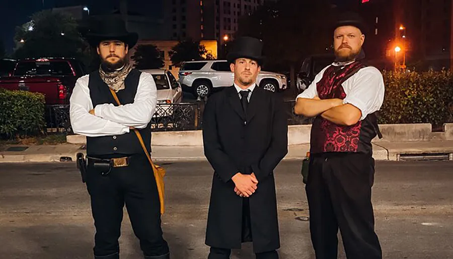 Three men stand confidently in historic or costume attire, reminiscent of the Wild West era, with the background revealing a modern urban night setting.