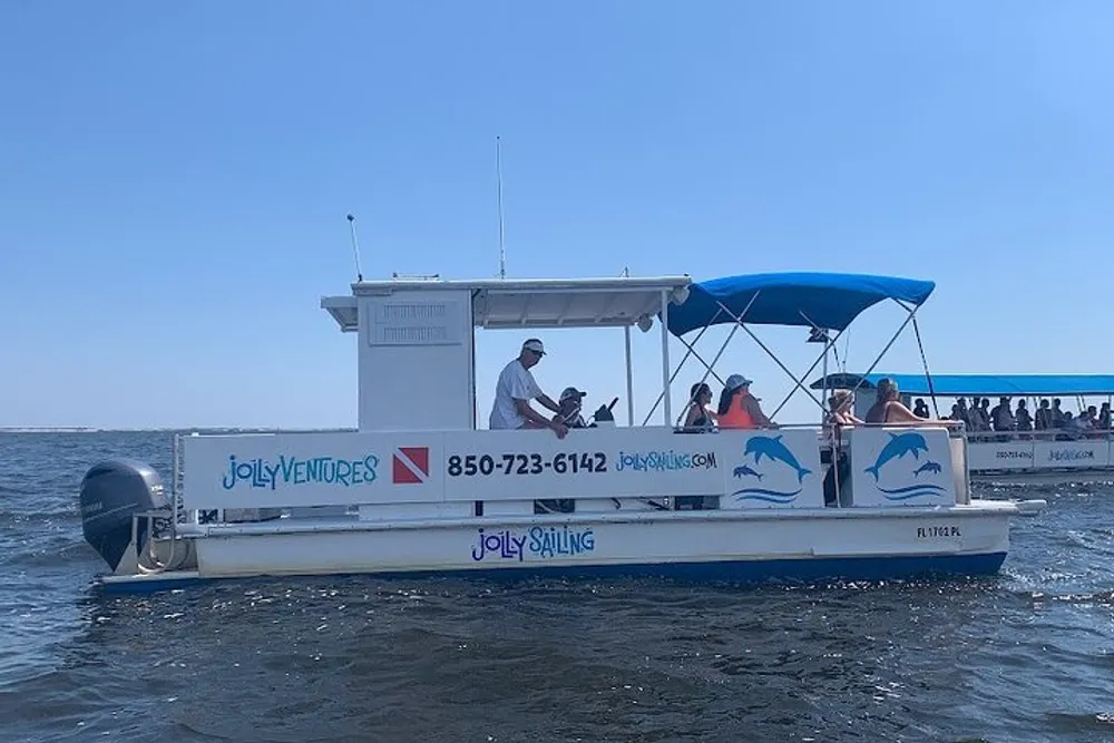 A group of people enjoy a sunny day on a small boat with a blue canopy out on the water