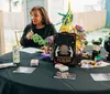 Two people are seated at a table with festive decorations and a sign suggesting a fortune-telling theme